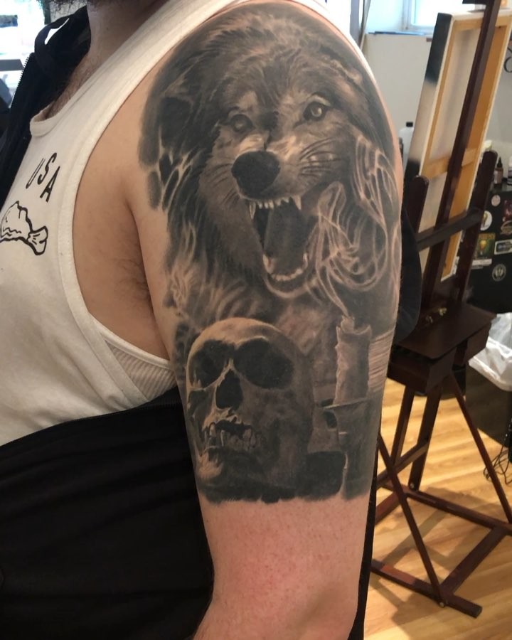 Black-and-grey wolf and skull half-sleeve