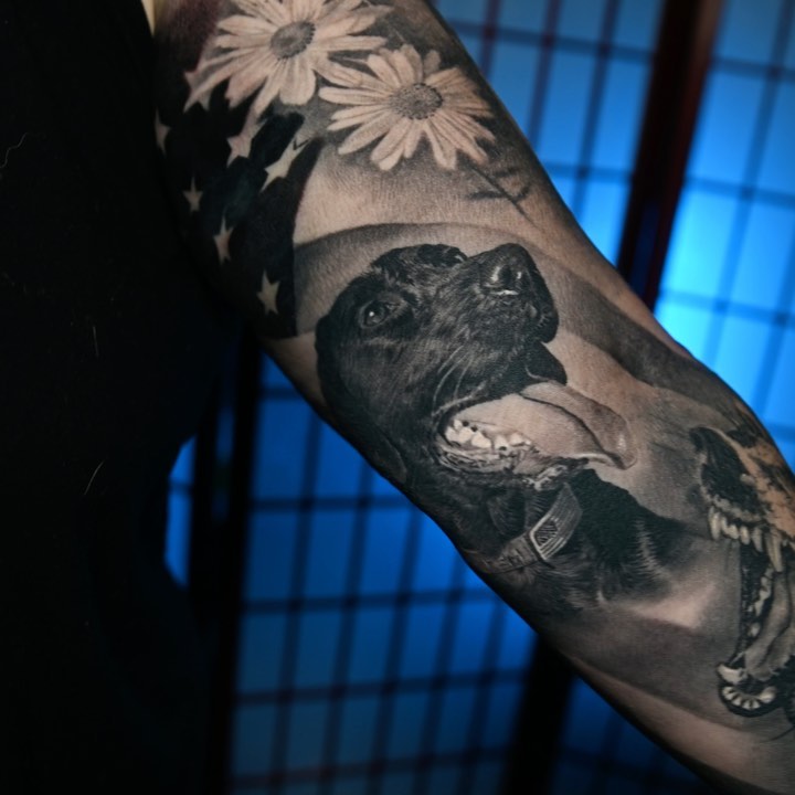 Black-and-grey dog portrait with daisies, arm