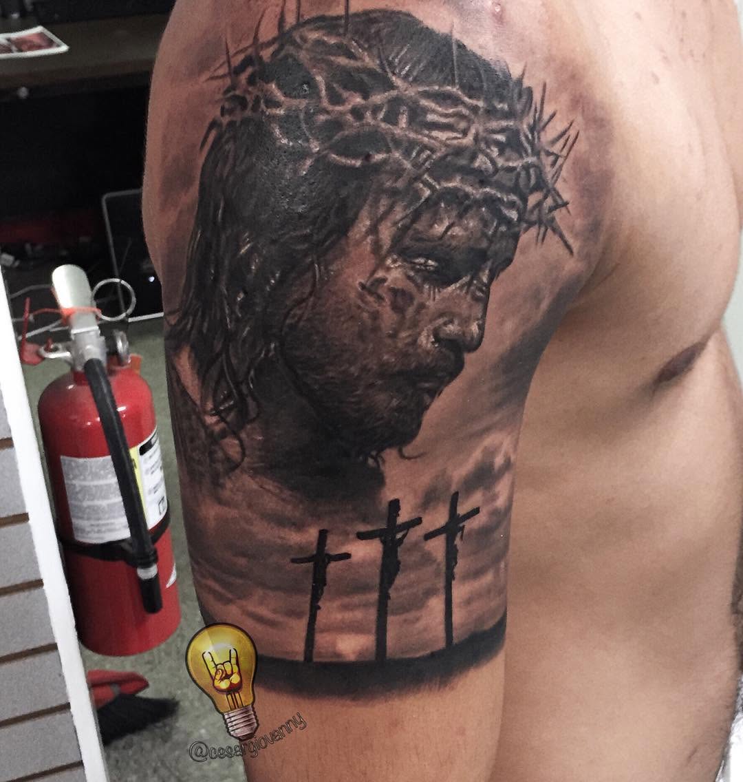 Black-and-grey Jesus portrait with crosses, arm