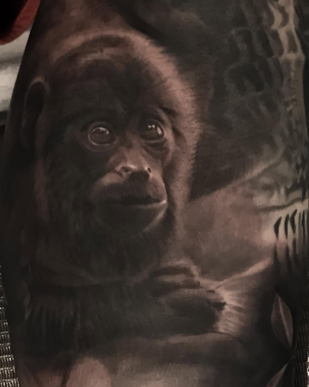 Black-and-grey orangutan portrait tattoo, arm
