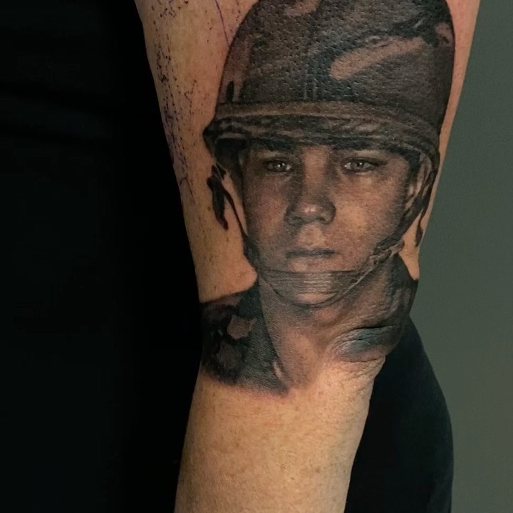 Black-and-grey soldier portrait tattoo, forearm