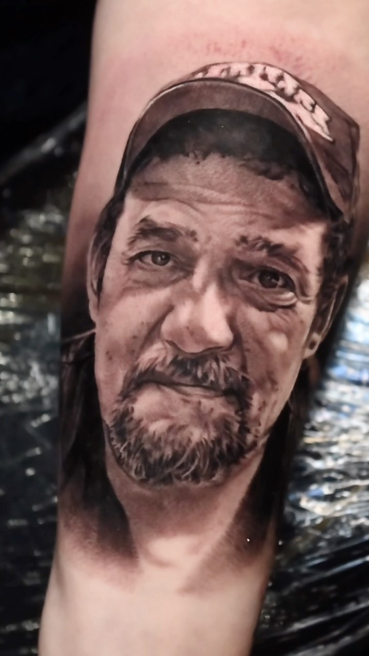 Black-and-grey portrait tattoo of late husband