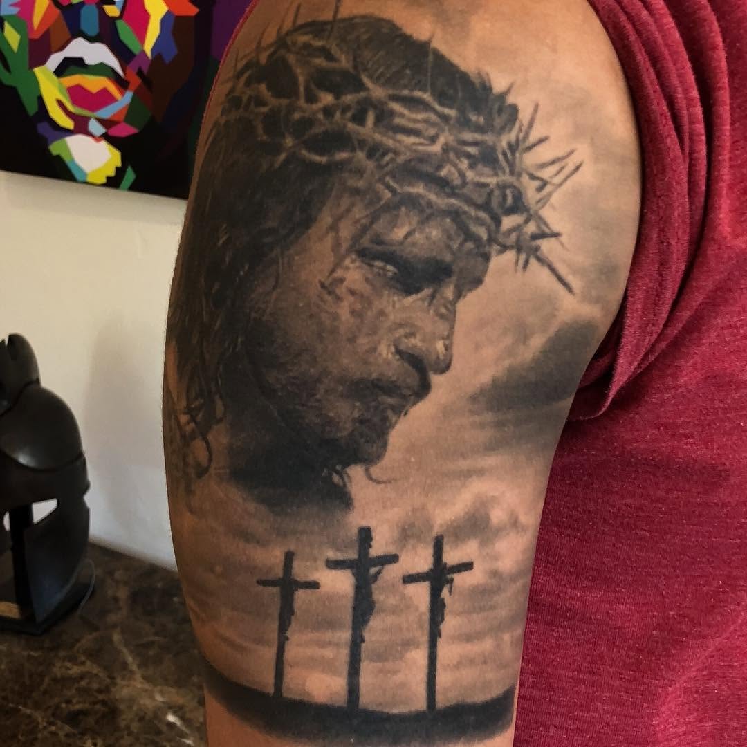Black-and-grey Jesus portrait tattoo, arm