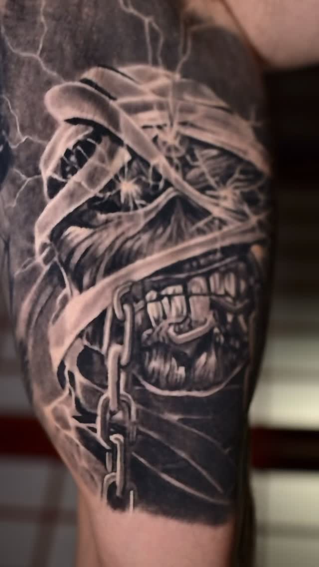 Black-and-grey Eddie Iron Maiden tattoo, thigh