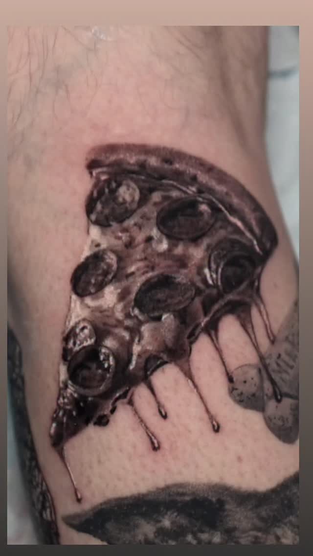 Black-and-grey realism pizza slice tattoo on leg