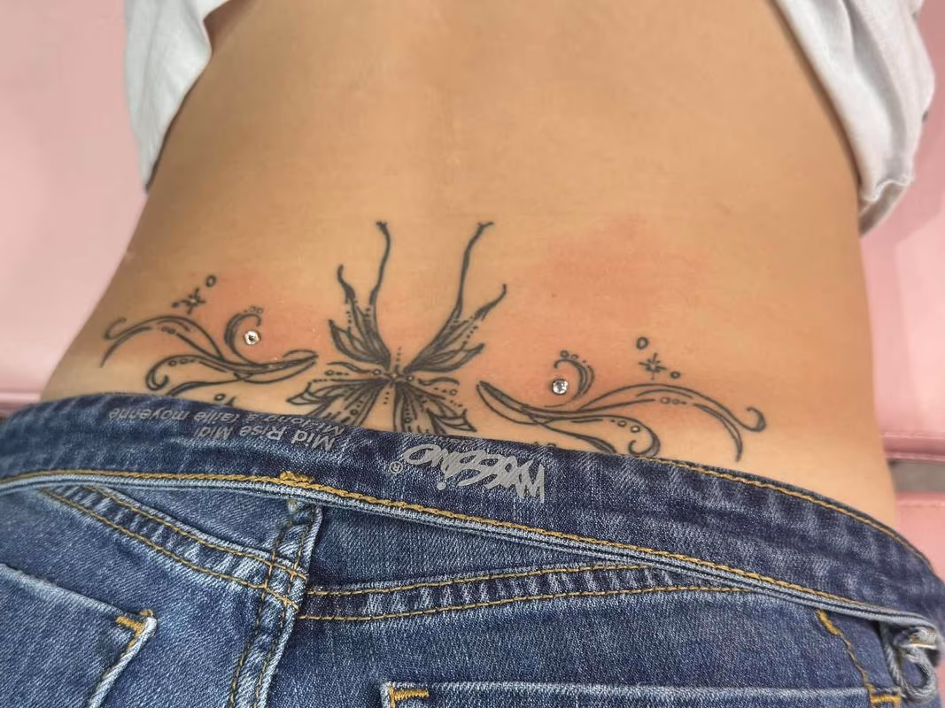 Back Dermal piercings adorning her tattoo