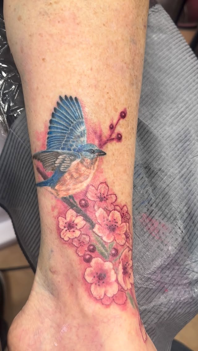 Blue bird with pink flowers, calf tattoo