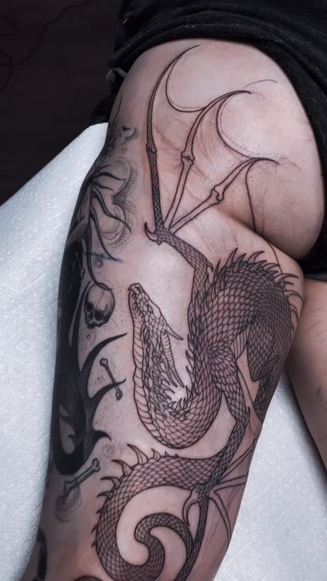 Black-and-grey dragon sleeve tattoo, arm