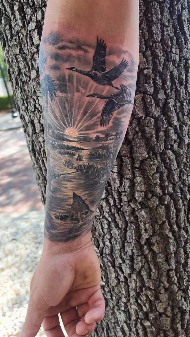 Realistic landscape with flying birds, calf tattoo