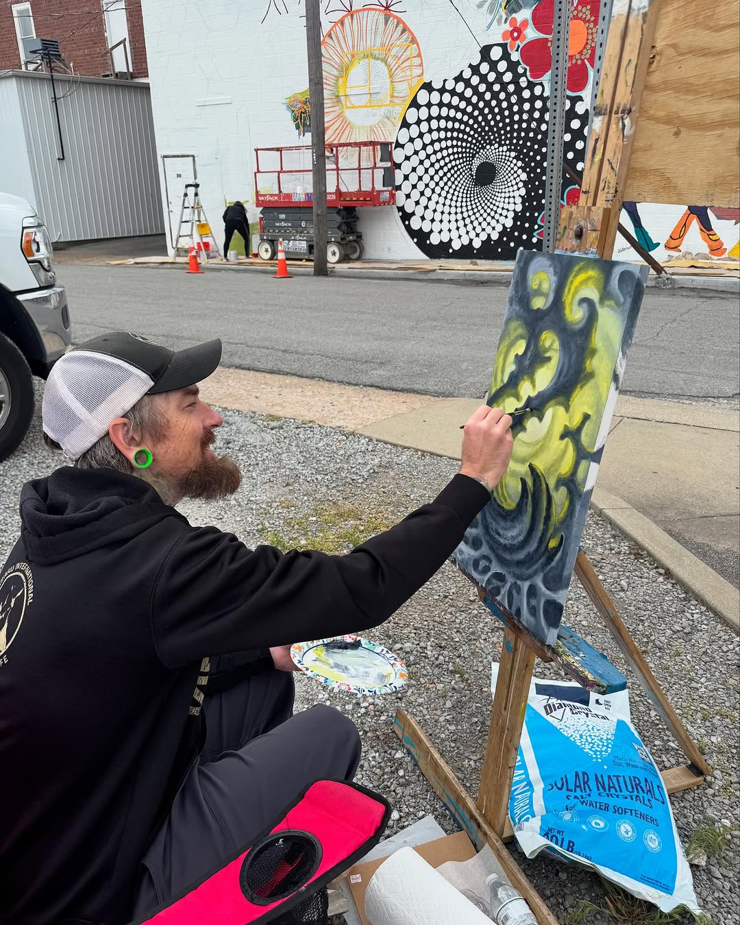 Artist painting abstract canvas outdoors