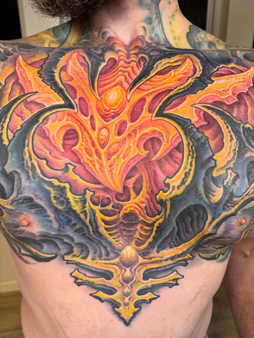 Biomechanical chest and upper-back tattoo in color