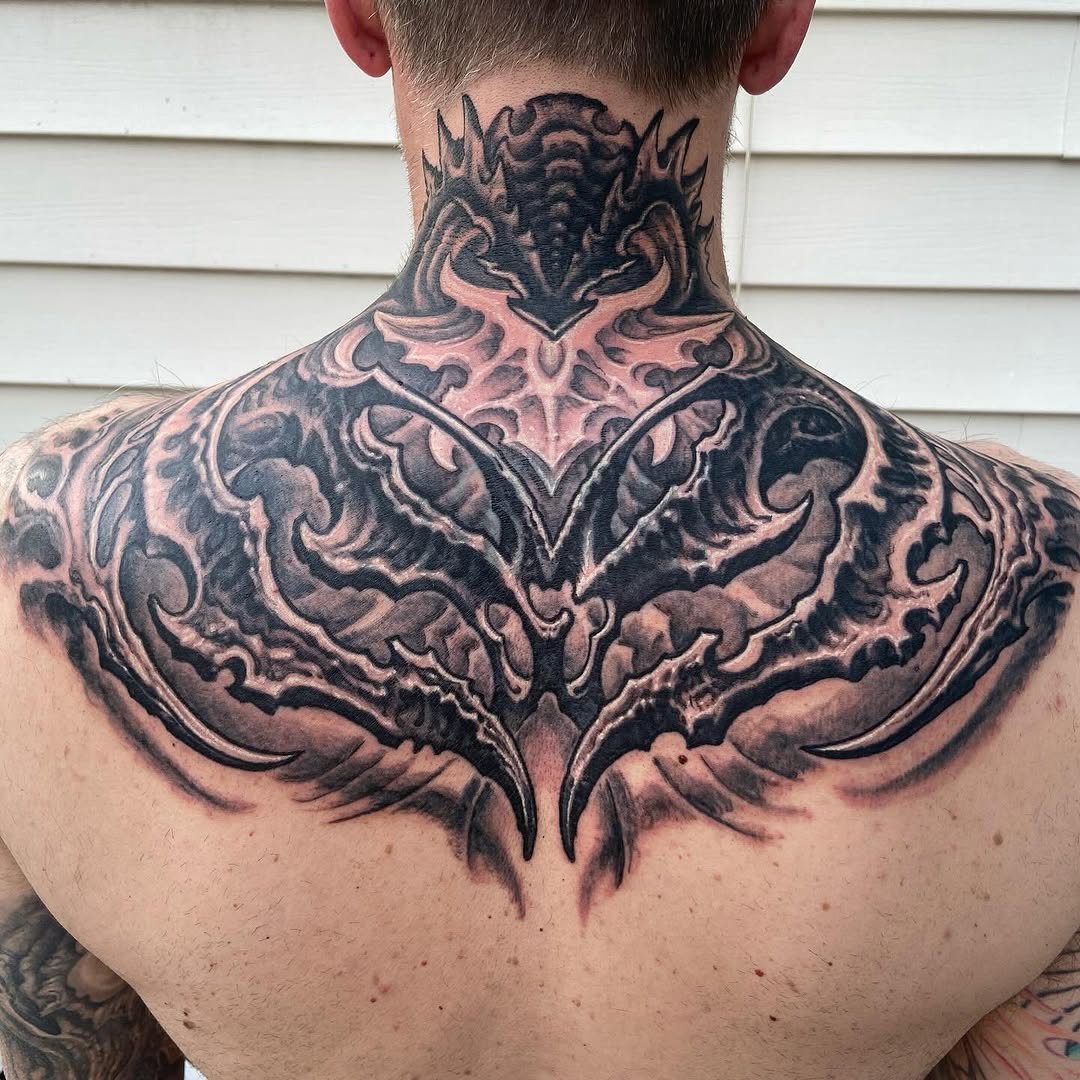 Biomechanical black-and-grey neck and upper back tattoo