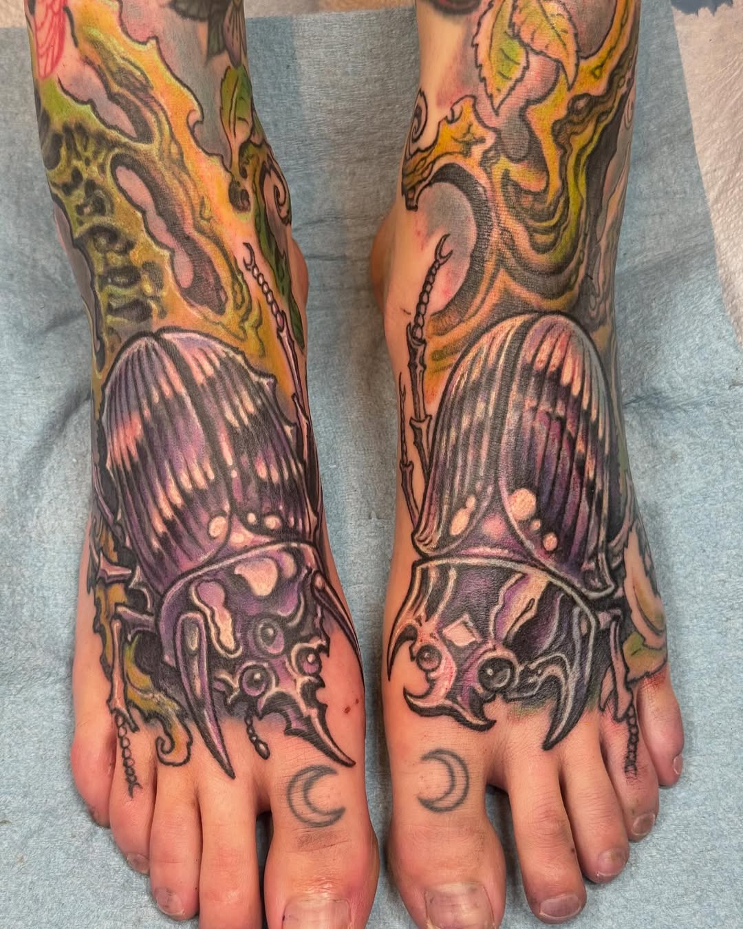 Matching scarab beetle coverup tattoos on feet