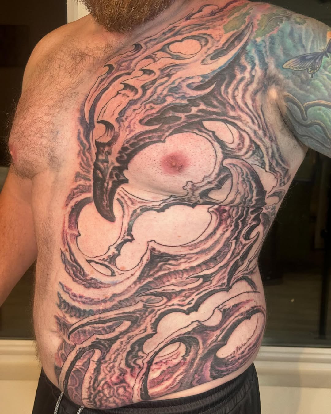 Biomechanical chest and stomach tattoo in black-and-grey