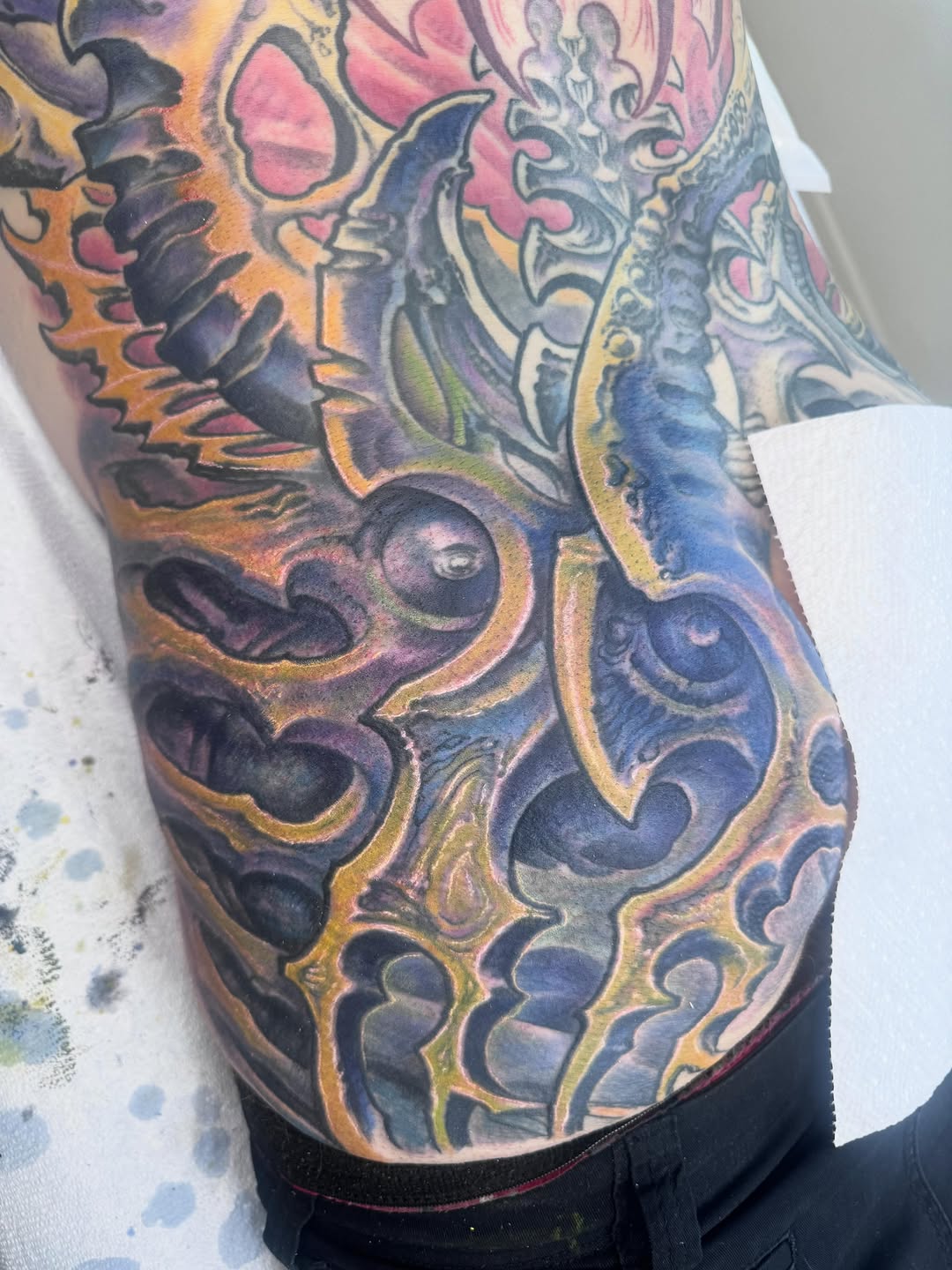 Biomechanical color tattoo on hip and side