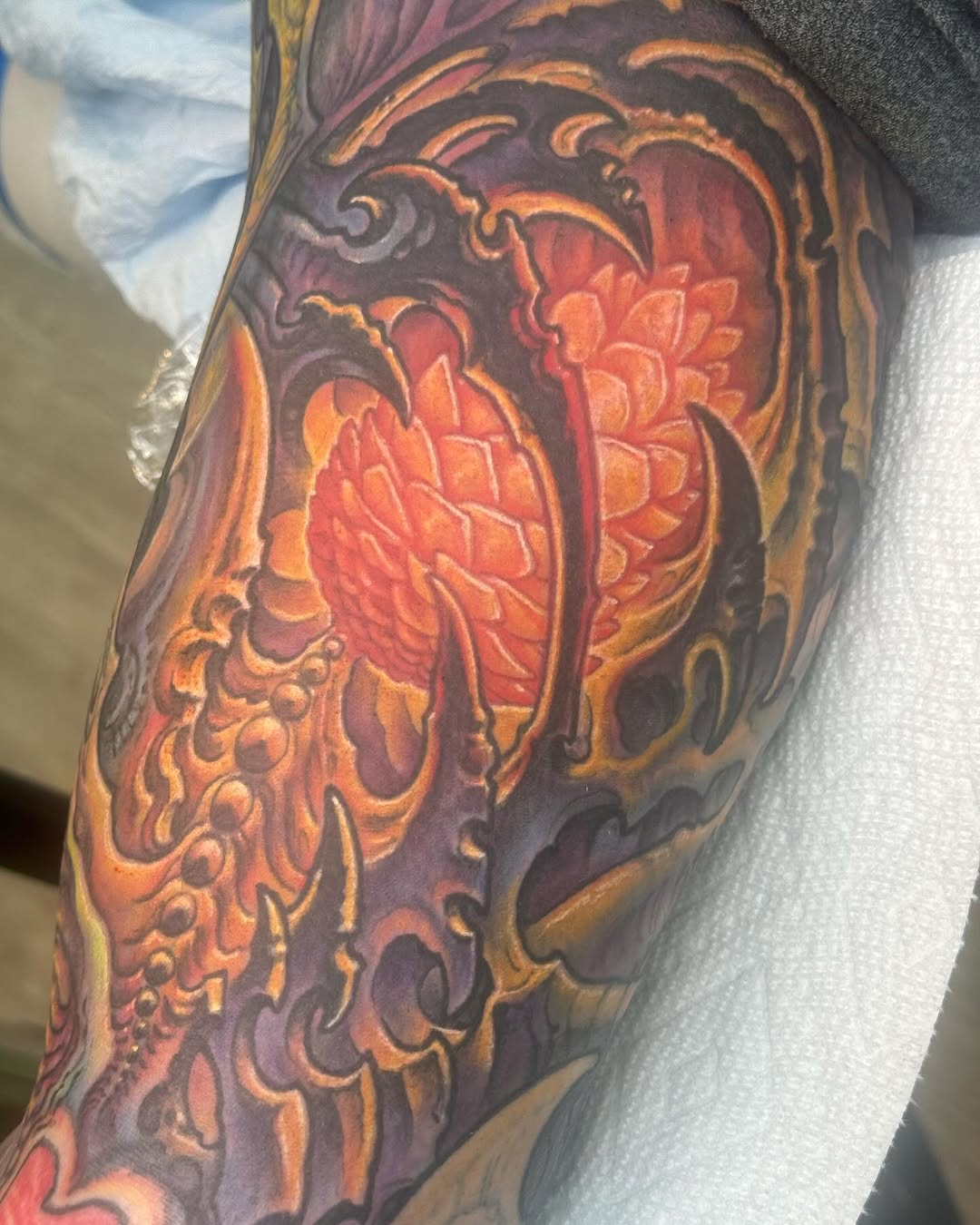 Biomech pinecone tattoo in orange and purple