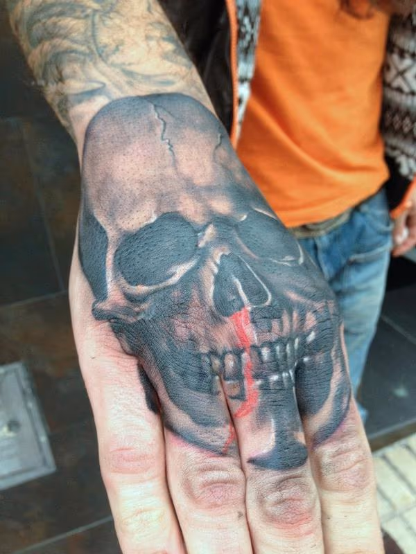 Black and grey skull hand tattoo