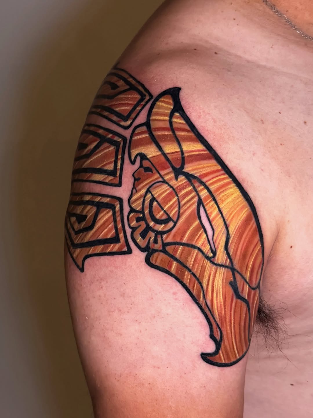 Aztec warrior shoulder tattoo in orange and black