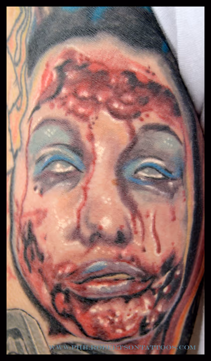 Healed photo of this little face on the back of an arm. zombie color tattoo