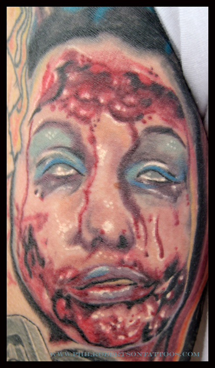 Healed photo of this little face on the back of an arm. zombie color tattoo