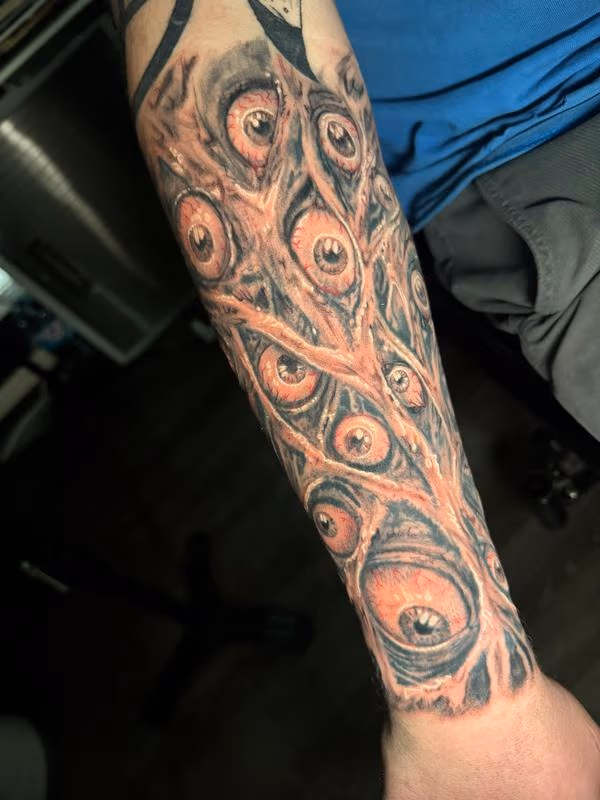 Creepy wandering eyes tattoo