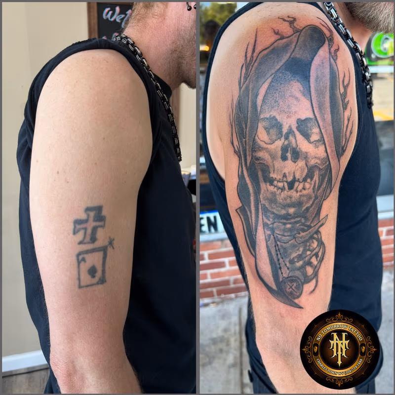 "A cover-up of an old tattoo featuring a skull draped in a shroud, with a cross hanging around its neck, rendered in striking black and grey tones."