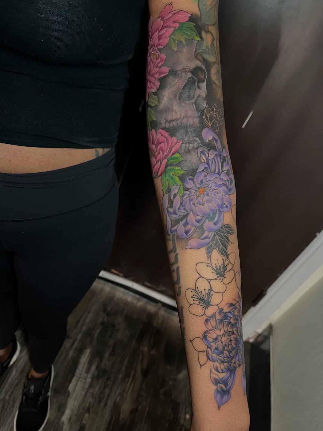 Skull and floral sleeve with pink peonies, purple flowers