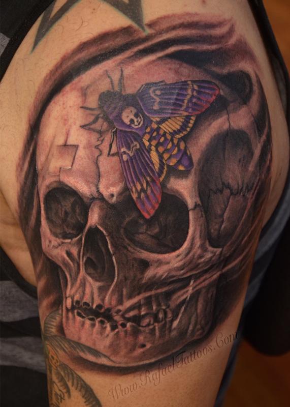 Black and grey weathered skull with purple moth tattoo