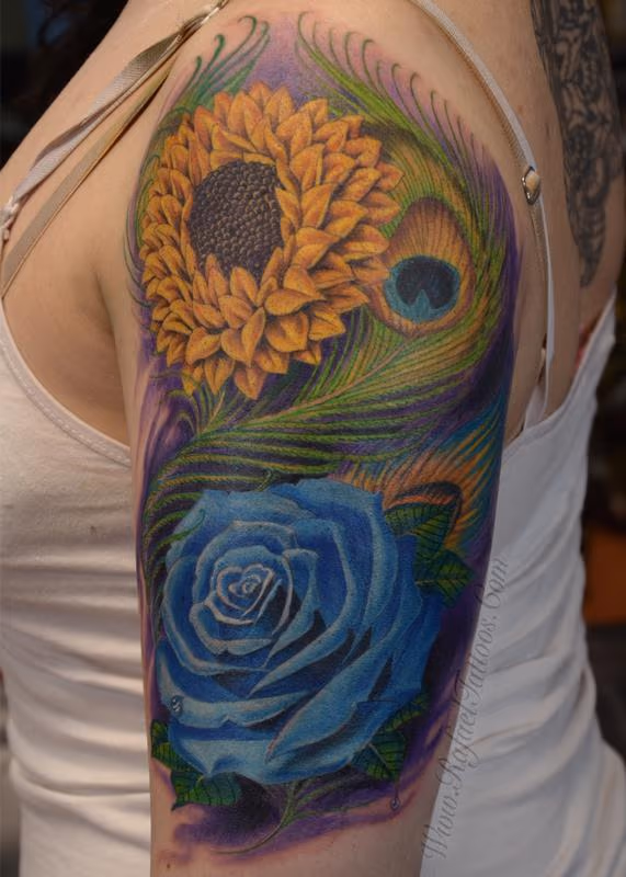Full colored blue rose and sunflower with peacock feathers arm tattoo