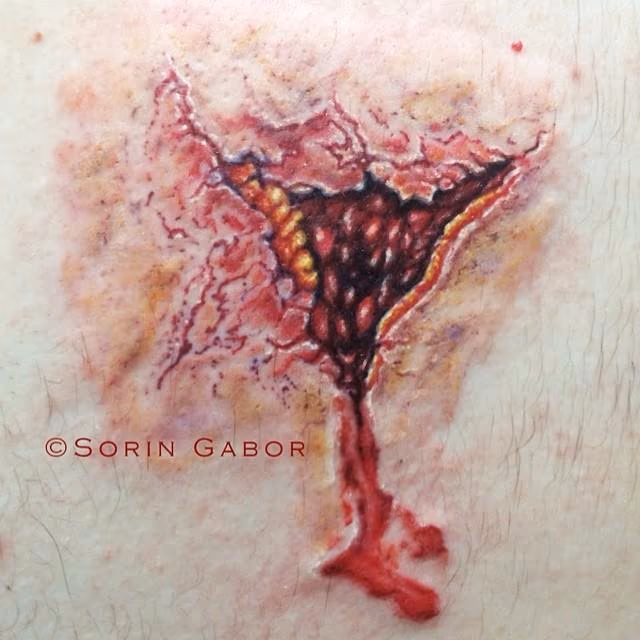 realistic color bullet hole tattoo on back- exit wound