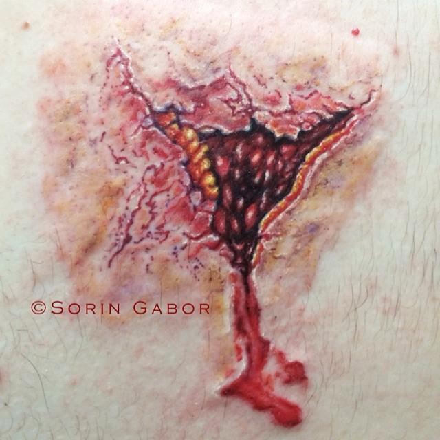 realistic color bullet hole tattoo on back- exit wound