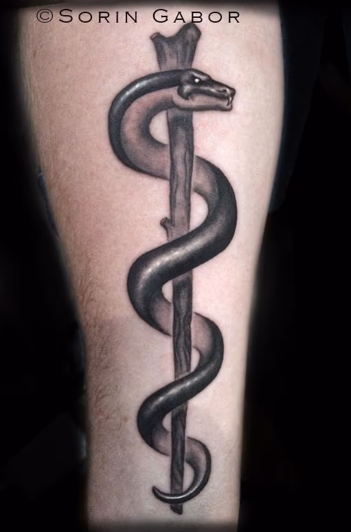 Illustrative black and gray caduceus snake and staff tatto