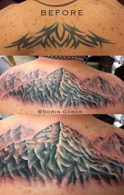 Realistic black and gray mountains over a tribal coverup