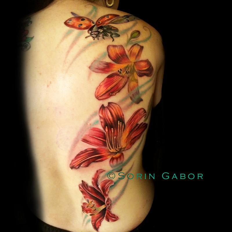Realistic color feminine tattoo of lillies and flying ladybug