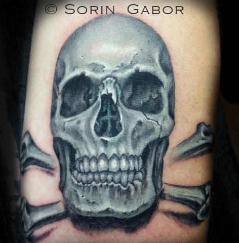 Realistic black and opaque gray skull tattoo on forearm