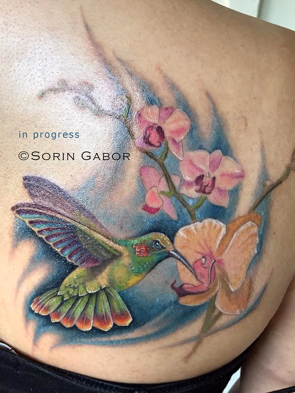 realistic color hummingbird and orchids tattoo
