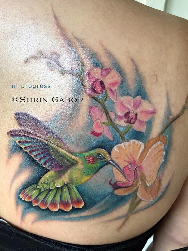 realistic color hummingbird and orchids tattoo