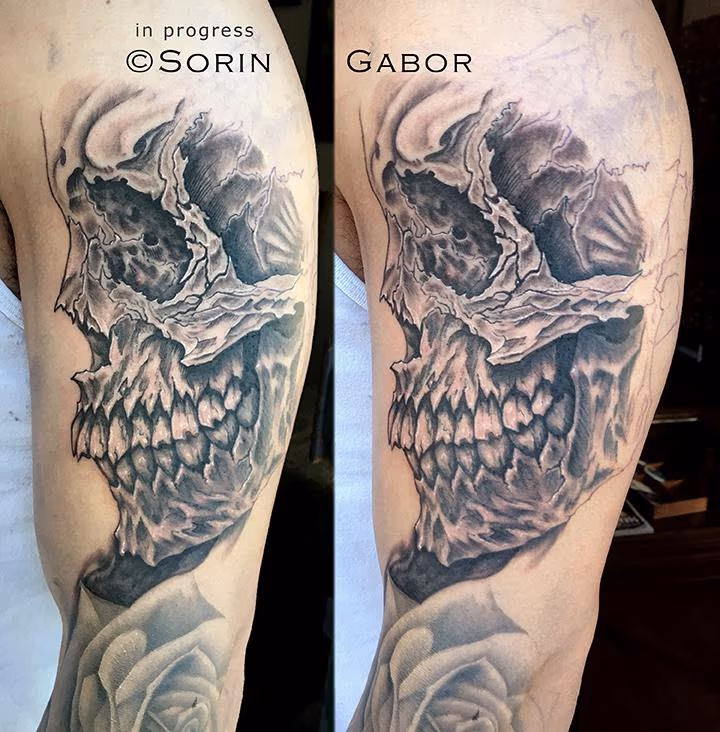 realistic and graphic black and gray sleeve tattoo in progress skull detail