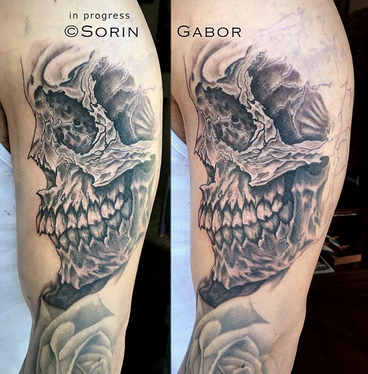 realistic and graphic black and gray sleeve tattoo in progress skull detail