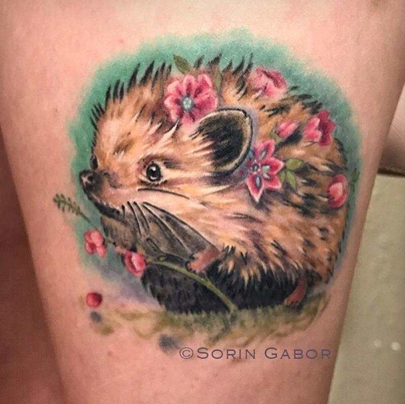 whimsical realistic color feminine hedgehog tattoo with flowers