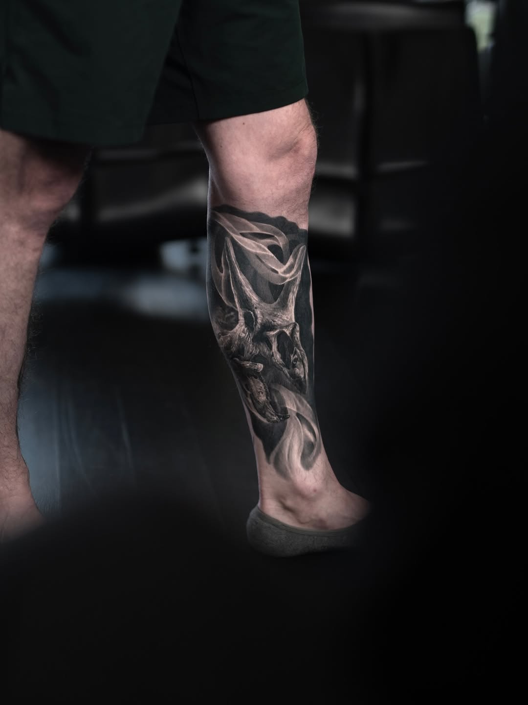 Black-and-grey triceratops forearm tattoo