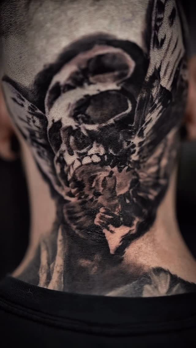 Black-and-grey skull neck tattoo