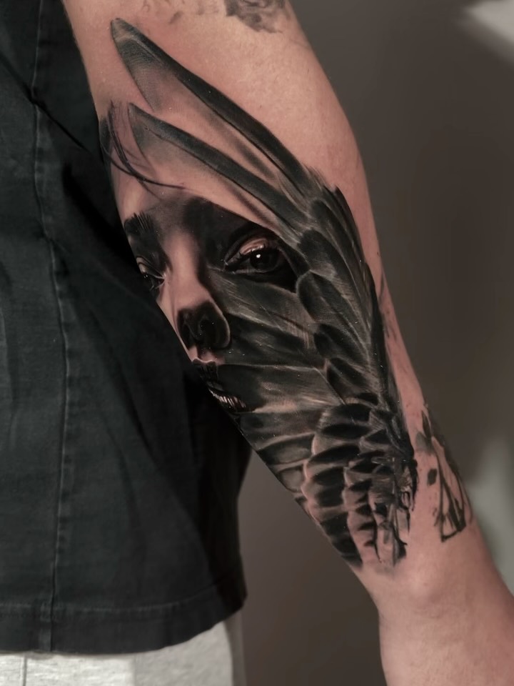 Black-and-grey raven coverup tattoo on arm