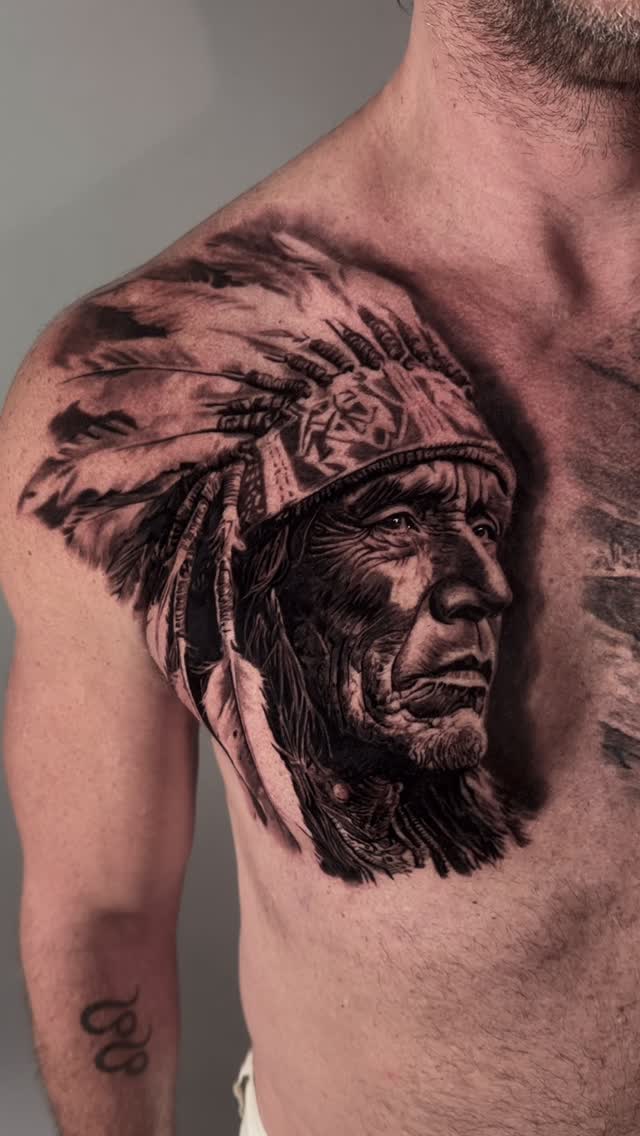 Native American chief portrait chest tattoo, black-and-grey