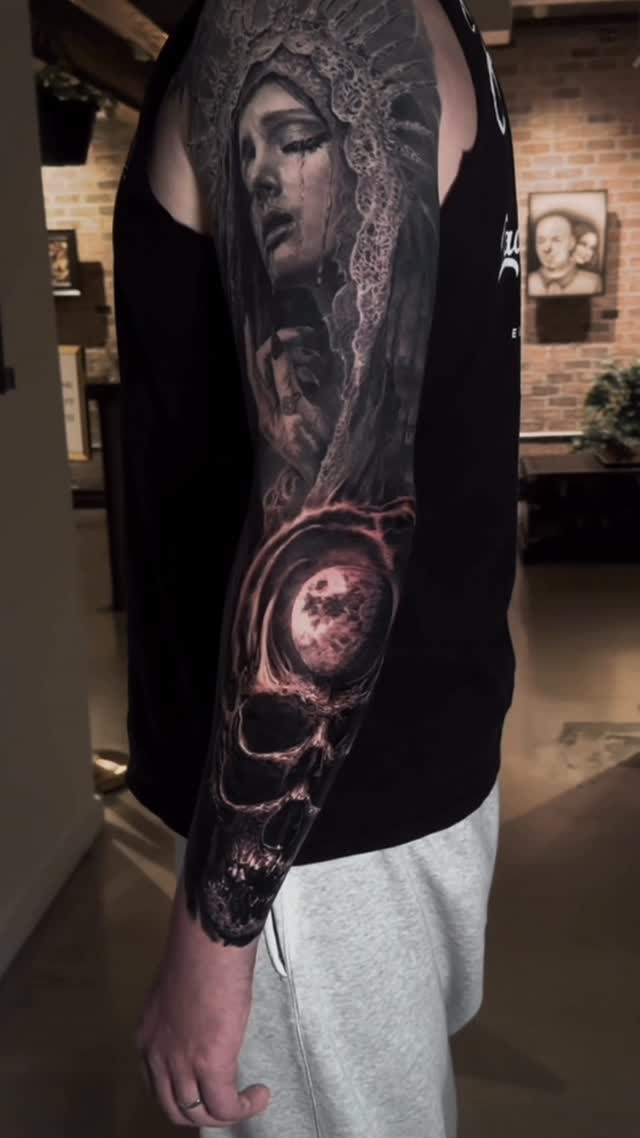 Portrait and skull sleeve in black and grey, arm