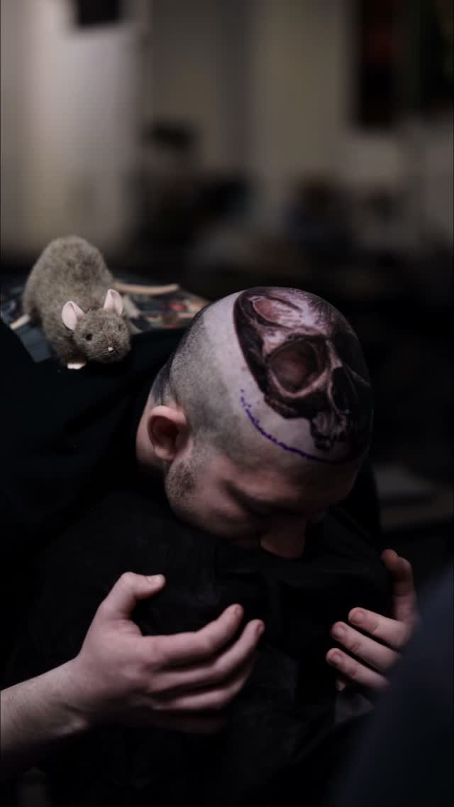 Black-and-grey skull head tattoo with surreal details