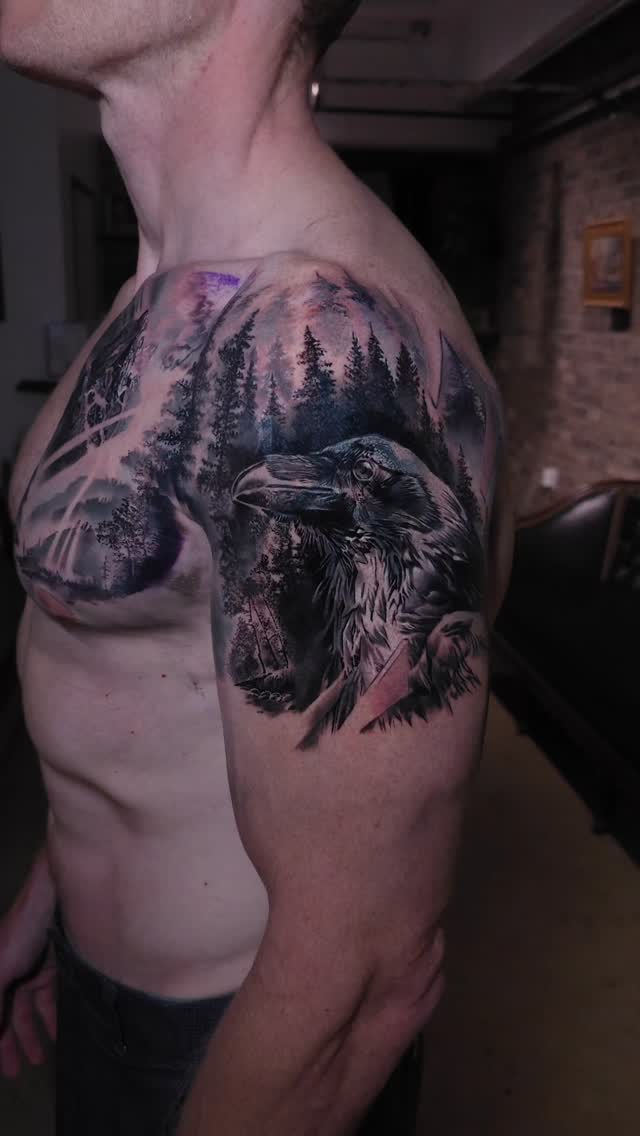Raven and forest landscape shoulder tattoo, black-and-grey