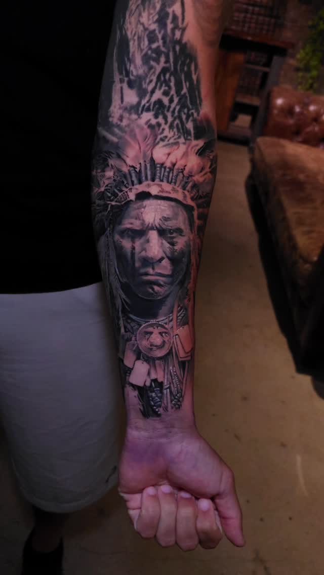 Native American portrait with feathered headdress, forearm