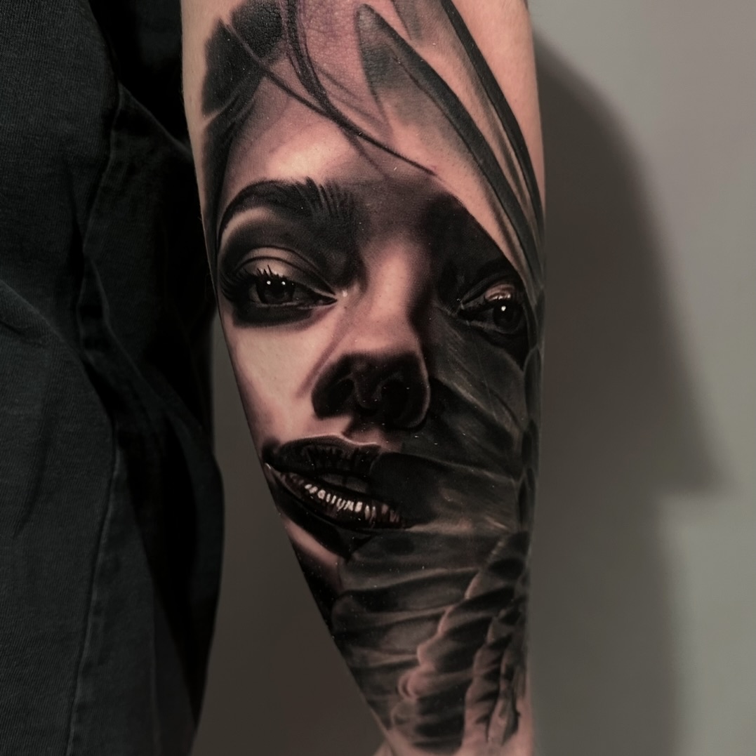 Black-and-grey portrait face with feathers, arm