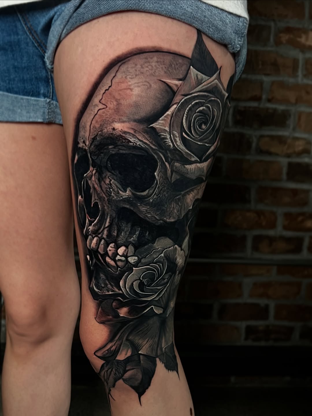 Black-and-grey skull with roses, thigh coverup